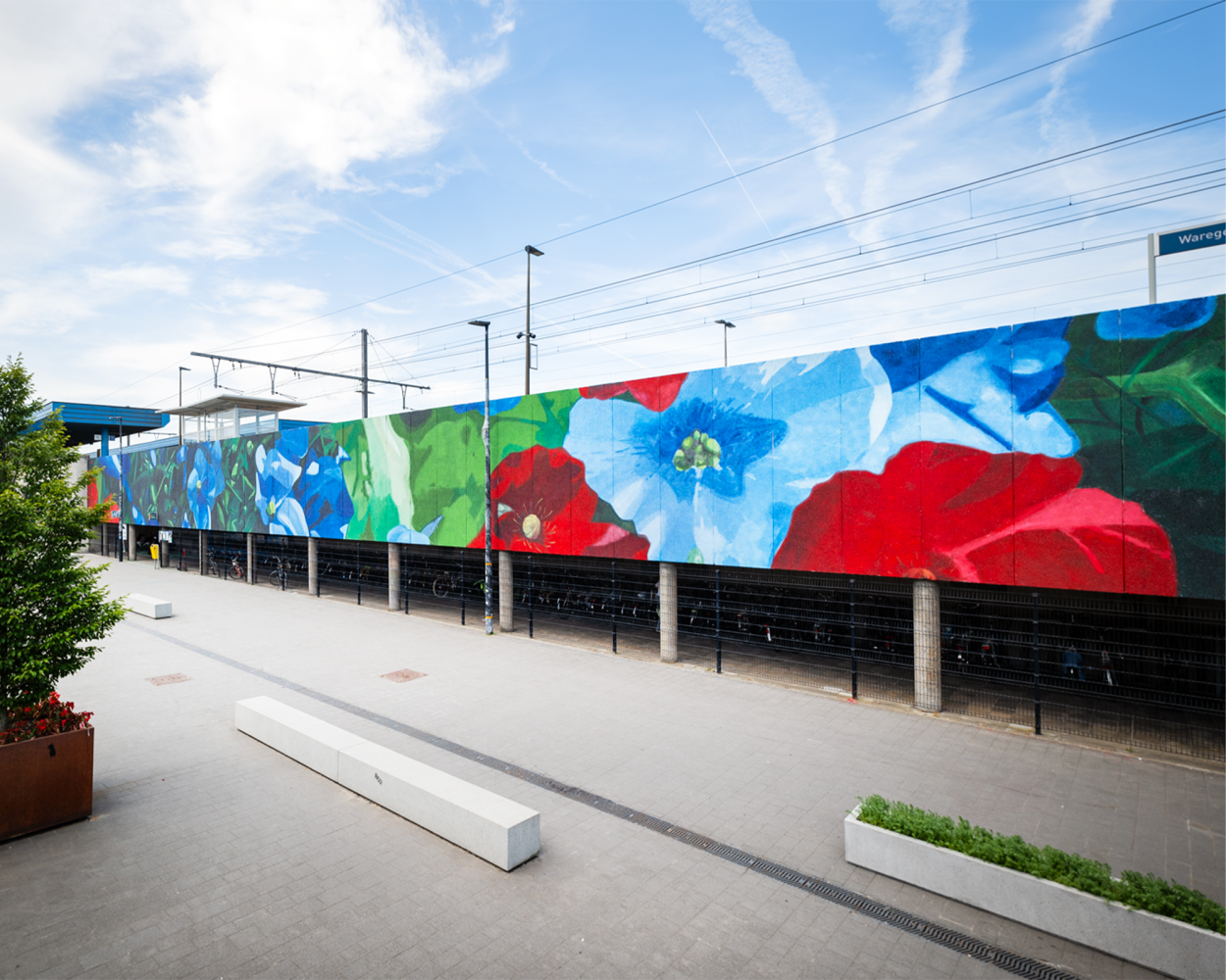 Mural met klaprozen in rood en blauw op de stationsgevel